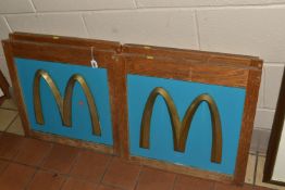 FOUR BRONZE MCDONALDS GOLDERN ARCH SHOP DISPLAY SIGNS, each mounted to a wooden frame, approximate