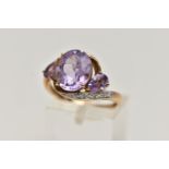 AN AMETHYST AND DIAMOND DRESS RING, principle oval cut amethyst with two additional pear cut