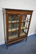 AN EDWARDIAN MAHOGANY AND STRUNG TWO DOOR DISPLAY CABINET, with two drawers, on square tapered legs,
