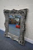 A SILVERED ORNATE RECTANGULAR WALL MIRROR, with a bevelled edge plate, 121cm x 101cm (condition