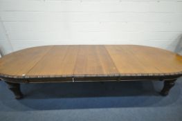 A LATE 19TH/EARLY 20TH CENTURY OAK WIND OUT DINING TABLE, with rounded ends, three additional