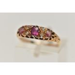 A YELLOW METAL GEM SET RING, a centrally set oval cut ruby, four old cut diamonds, two oval cut pink