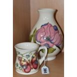 A MOORCROFT POTTERY MUG AND VASE, comprising a 'Butterfly' mug designed by Rachel Bishop, tube lined