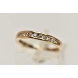A YELLOW METAL DIAMOND HALF ETERNITY RING, designed as a row of ten channel set, round brilliant cut