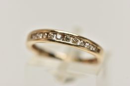 A YELLOW METAL DIAMOND HALF ETERNITY RING, designed as a row of ten channel set, round brilliant cut