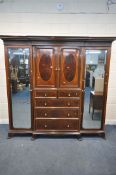 A WARING OF LONDON MAHOGANY COMPACTUM WARDROBE, the double bevelled edge mirror doors, flanking