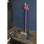 A DYSON V7 MOTORHEAD CORDLESS VACUUM CLEANER with two charging brackets, a spare pipe and head (