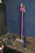 A DYSON V7 MOTORHEAD CORDLESS VACUUM CLEANER with two charging brackets, a spare pipe and head (