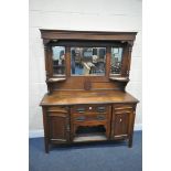 AN ARTS AND CRAFTS OAK MIRROR BACK SIDEBOARD, with triple bevelled edge mirrors, cupboard doors