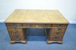 A REPRODUCTION MAHOGANY TWIN PEDESTAL DESK, with a tan leather writing surface, blind fretwork