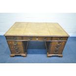 A REPRODUCTION MAHOGANY TWIN PEDESTAL DESK, with a tan leather writing surface, blind fretwork