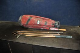 FOUR VINTAGE HICKORY SHAFTED GOLF CLUBS including a Tom Tropp Jigger, a brass topped putter and a