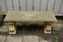 A COMPOSITE GARDEN BENCH, with a rectangular top resting on twin scrolled pedestals, length 120cm