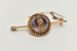 A VICTORIAN BROOCH, principal cabochon amethyst, decorated with a centrally positioned band of