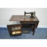 A VINTAGE OAK CASED SINGER TREADLE SEWING MACHINE, serial number y8502015, with an assortment of