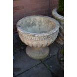 A WEATHERED CIRCULAR COMPOSITE GARDEN URN, on a seperate plinth base, diamater 54cm x height 47cm (