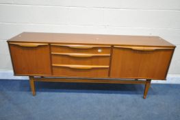A MID CENTURY TEAK SIDEBOARD, with a fall front door, double cupboard doors that are both flanking
