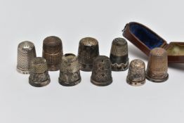A LATE VICTORIAN WOODEN CASED SILVER THIMBLE AND EIGHT OTHER SILVER / WHITE METAL THIMBLES, the