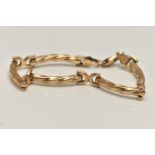 A 9CT GOLD FANCY LINK BRACELET, designed as a series of curved textured bars, fitted with a