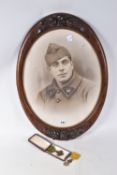 A FRAMED PHOTO OF A FRENCH SOLDIER AND TWO MEDALS, the picture is in a carved wooden frame and