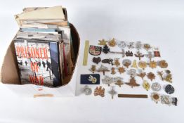 A BOX CONTAINING OVER THIRTY FIVE CAP BADGES, and an assortment soft back magazines relating to