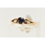 A YELLOW METAL SAPPHIRE AND DIAMOND RING, set with a central circular cut deep blue sapphire,
