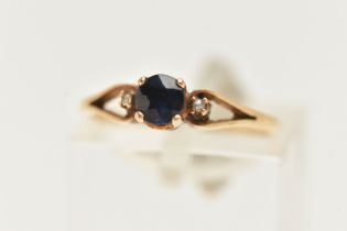 A YELLOW METAL SAPPHIRE AND DIAMOND RING, set with a central circular cut deep blue sapphire,