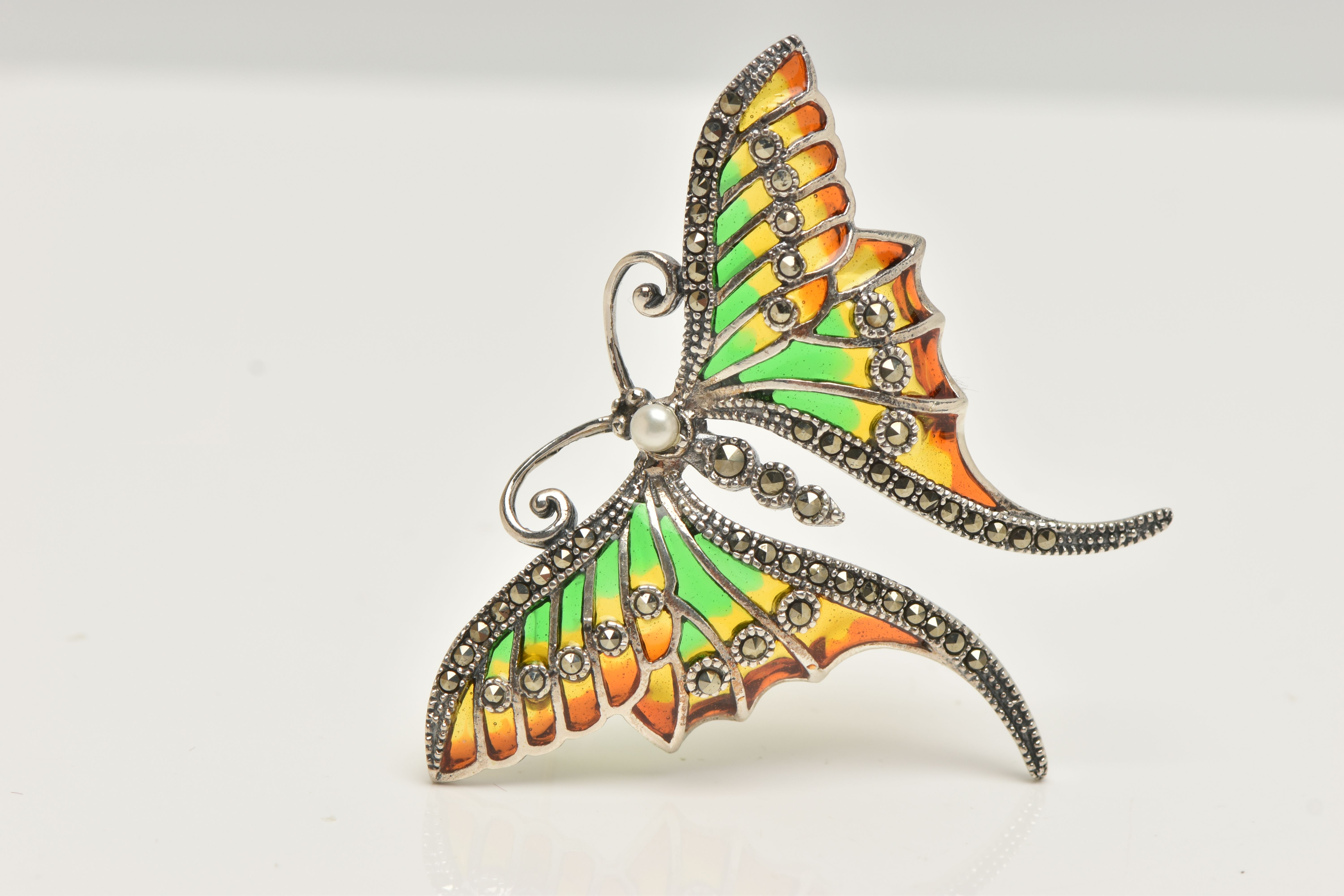 A WHITE METAL PLIQUE A JOUR BROOCH, in the form of butterfly with red, green and yellow enamel