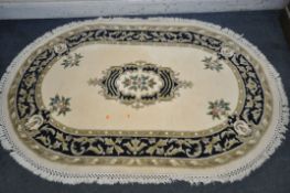 AN OVAL CHINESE WOOLLEN RUG, 190cm x 127cm (condition report: few stains)