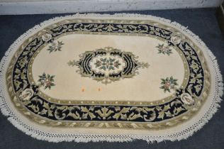 AN OVAL CHINESE WOOLLEN RUG, 190cm x 127cm (condition report: few stains)