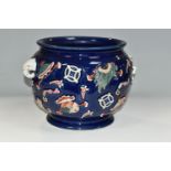 A CHINESE PORCELAIN TWIN HANDLED JARDINIERE, the blue ground with relief moulded with fans, purses