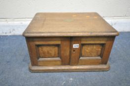AN EARLY 20TH CENTURY OAK CUTLERY CABINET, the two doors enclosing three drawers, with brass