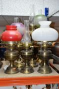 A GROUP OF EIGHT VICTORIAN OIL LAMPS, mainly brass and metal bases, assorted coloured glass
