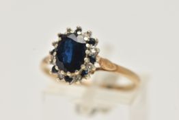A 9CT GOLD SAPPHIRE CLUSTER RING, oval cut sapphire, prong set with alternating sapphires and single