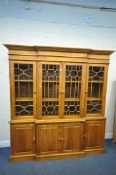 A LARGE SOFTWOOD BREAKFRONT GLAZED FOUR DOOR DISPLAY CABINET, over four fielded panel cupboard