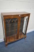 AN EARLY 20TH CENTURY WALNUT TWO DOOR CHINA CABINET, with three glass shelves, on cabriole legs,