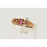 A GEM SET RING, an oval cut pink paste stone with two round cut spinels, prong set in yellow