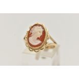 A 9CT GOLD CAMEO RING, carved shell cameo, collet set within a fine rope twist and scallop surround,