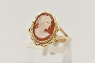 A 9CT GOLD CAMEO RING, carved shell cameo, collet set within a fine rope twist and scallop surround,