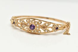 A 9CT GOLD AMETHYST AND SEED PEARL HINGED BANGLE, floral pattern bangle set with three circular