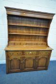 A REPRODUCTION OAK DRESSER, the top section with two tiered plate racks, and seven small drawers,