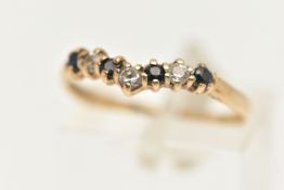 A 9CT GOLD CUBIC ZIRCONIA WISH BONE RING, set with a row of blue and colourless cubic zirconia, to a