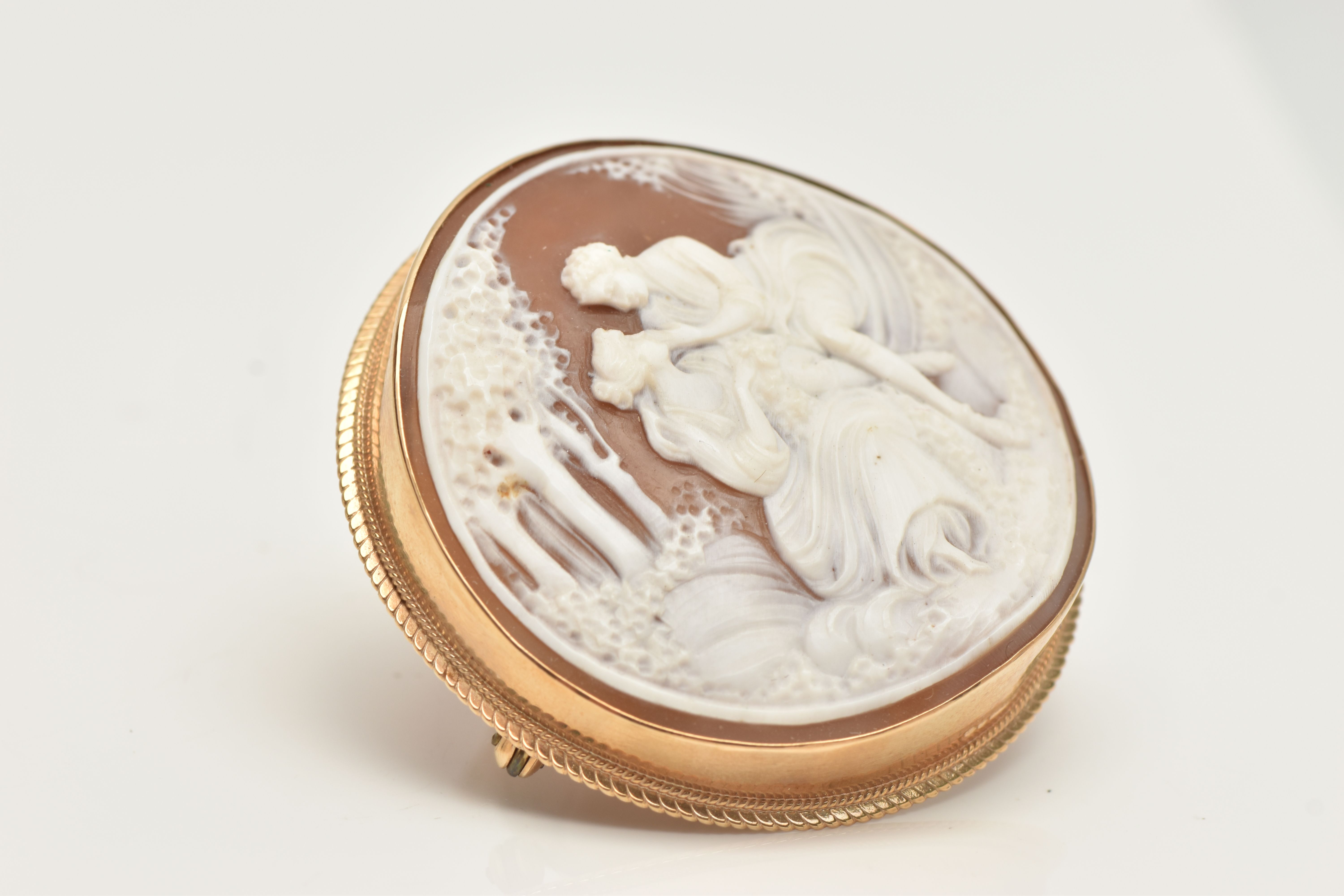 A 9CT GOLD CAMEO BROOCH, of a circular form, carved shell cameo depicting a couple scene, collet set - Image 2 of 3