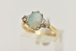 AN 18CT GOLD OPAL AND DIAMOND RING, designed as a central oval opal flanked by brilliant cut