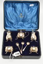 A CASED GEORGE V SILVER FIVE PIECE CRUET SET AND THREE CONDIMENT SPOONS, the cruet set comprising