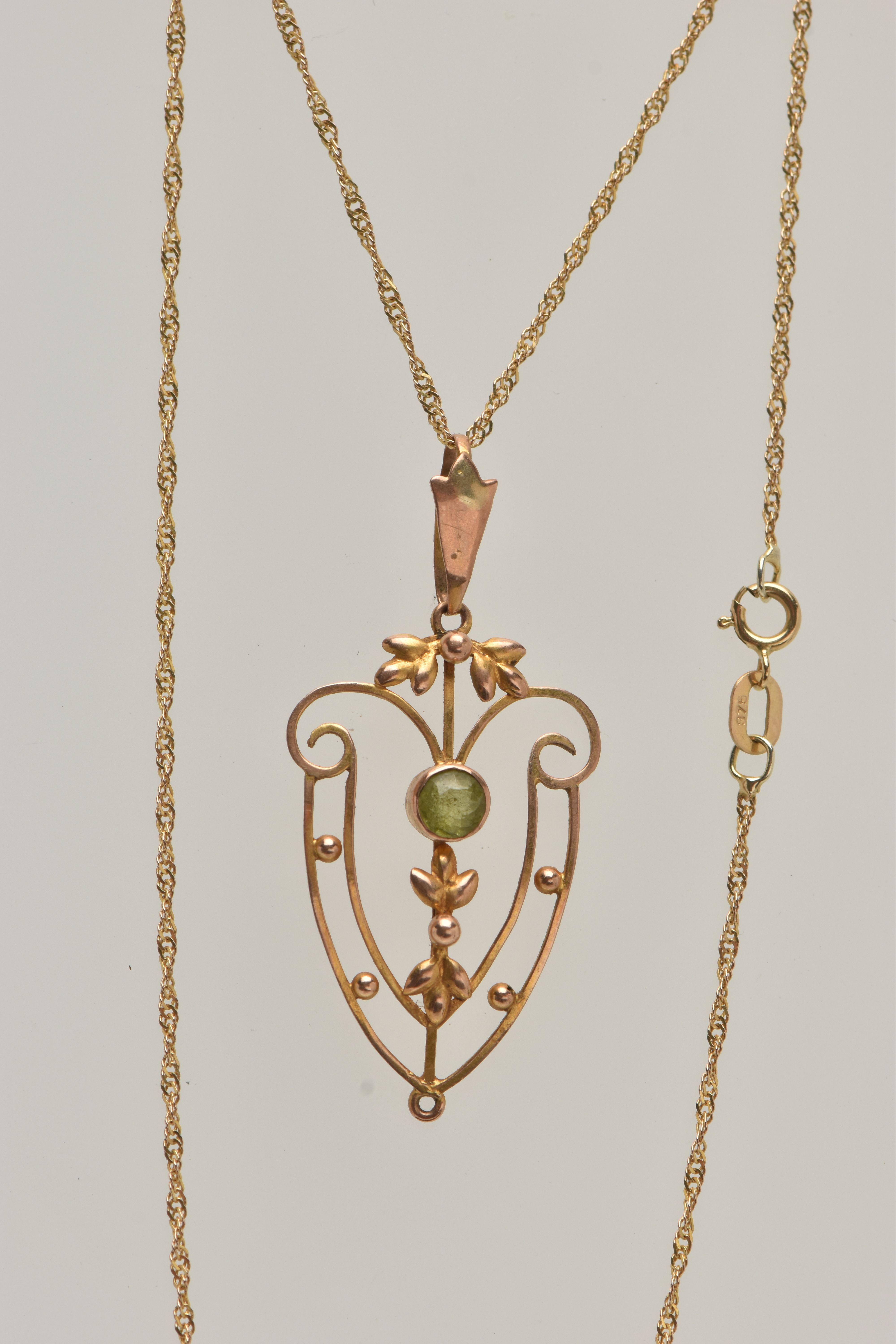 AN EDWARDIAN PENDANT AND CHAIN, open work floral pendant, set with a circular cut peridot, missing