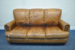 A TAN STUDDED LEATHER THREE SEATER SETTEE, length 184cm (condition report: cracks to arm rests,