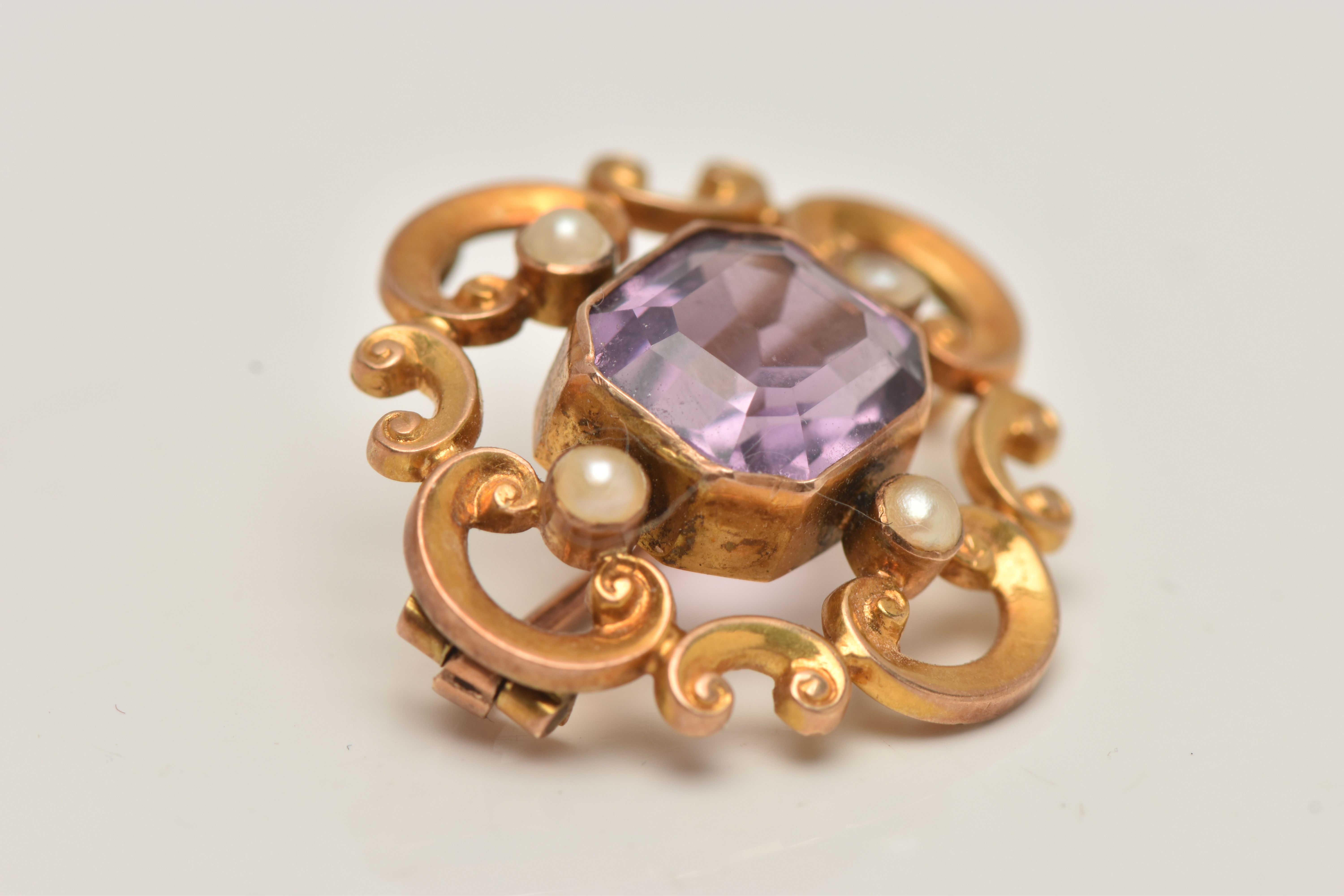 A YELLOW METAL AMETHYST AND SEED PEARL BROOCH, open work scrolling brooch set with a central emerald - Image 2 of 4