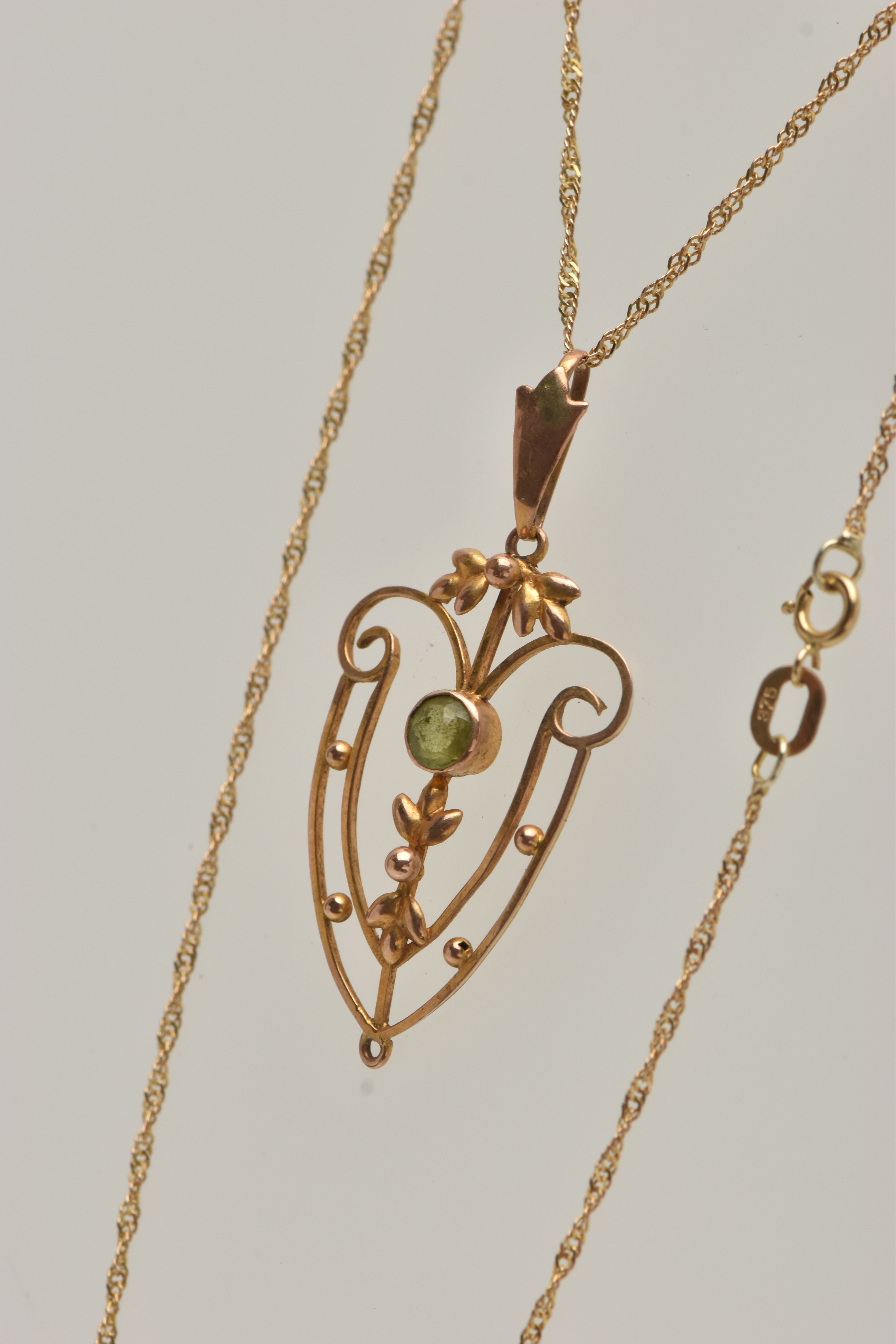 AN EDWARDIAN PENDANT AND CHAIN, open work floral pendant, set with a circular cut peridot, missing - Image 4 of 4