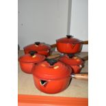 A SET OF FIVE LE CREUSET RED SAUCEPANS, all with lids, comprising sizes 14,16,18,20,22 (5) (